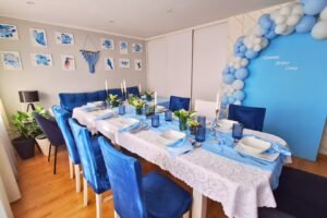 Dekoracja komunijna biało-niebieska w domu ze ścianką balonową