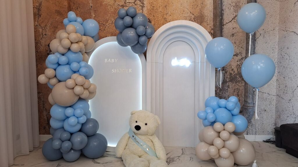 Ścianka z balonów w błękicie, granacie i beżu z białymi łukami i misiem – baby shower w Łodzi