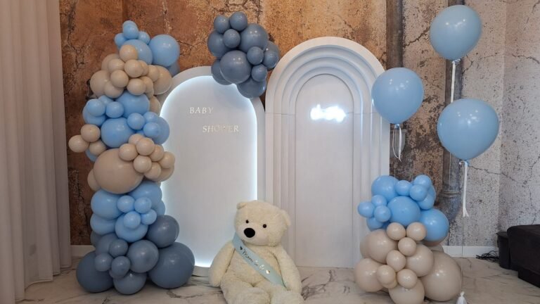 Ścianka z balonów w błękicie, granacie i beżu z białymi łukami i misiem – baby shower w Łodzi