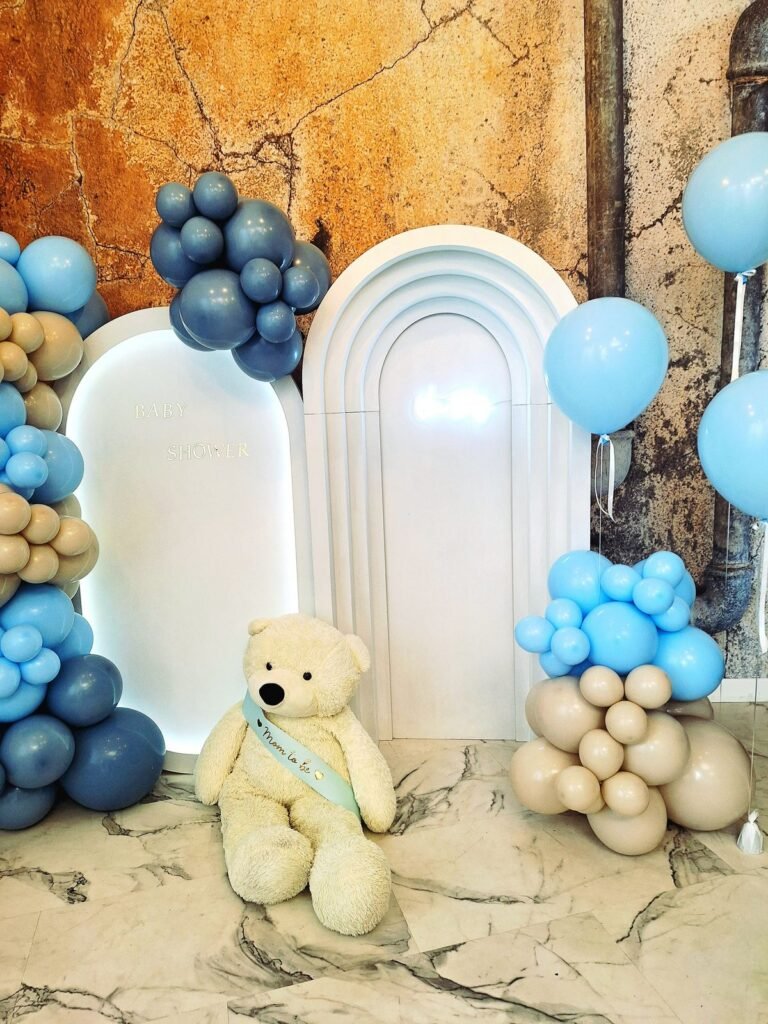 Balony w odcieniach błękitu i beżu przy białych łukach – baby shower w Łodzi