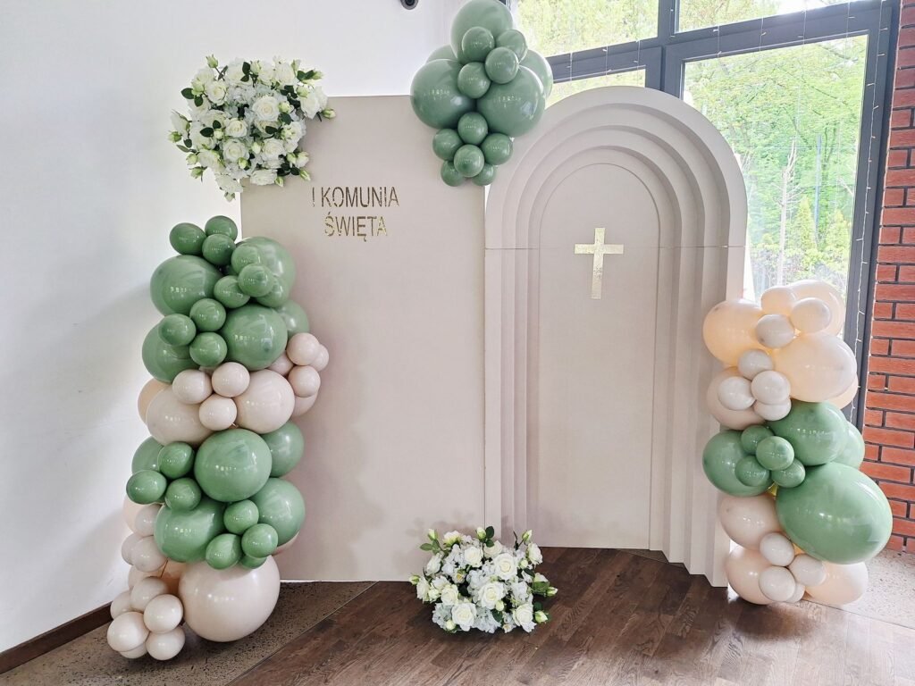 Ścianka komunijna z łukami, krzyżem i balonami w szałwii i beżu – komunia w Łodzi